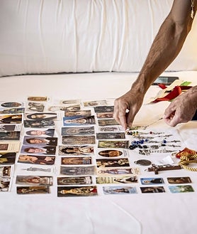 Imagen secundaria 2 - Paco Robleño, tío del matador y modo de espadas, le ayuda a vestir el humano miedo de valor de luces. Aún está reciente la cicatriz de los Sanfermines. Robleño pide silencio y extiende sus estampas sobre la cama. 