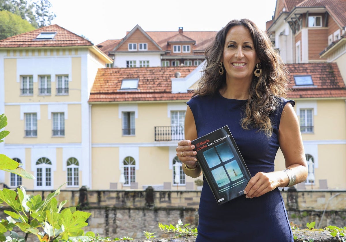 María Oruña posa junto a su novela frente al balneario de Puente Viesgo