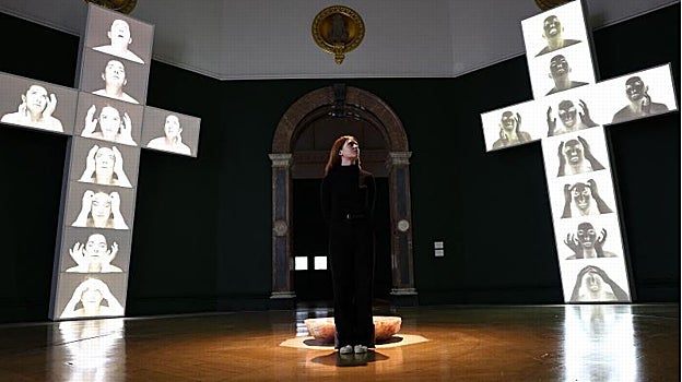 Una joven posa en la instalación 'Cuatro cruces', de Marina Abramovic