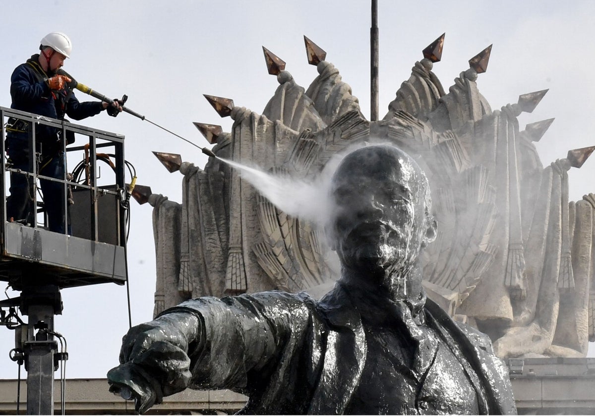 Un operario limpia la estatua de Lenin de la plaza de Moscú, en San Petersburgo