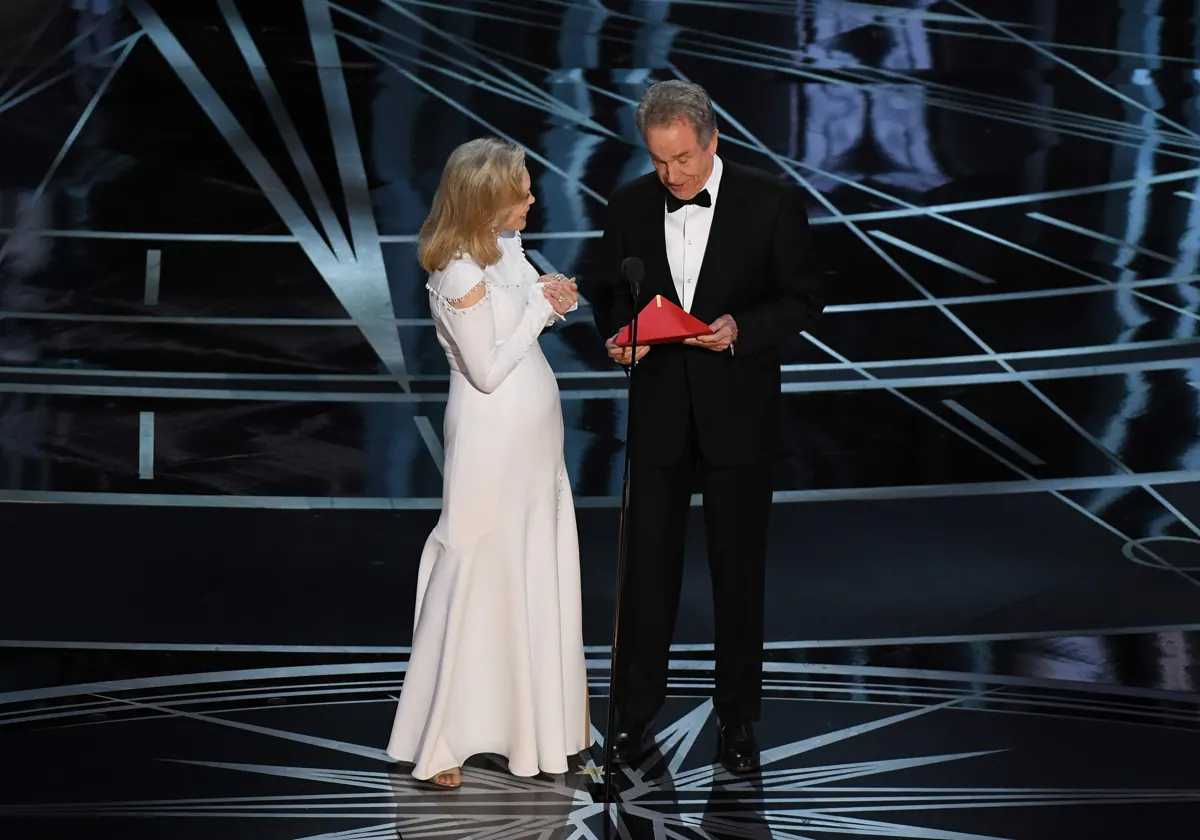 Faye Dunaway mira a Warren Beatty dubitativo al abrir el sobre con la película premiada