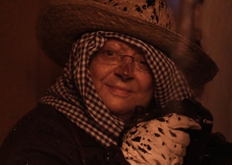 Imagen secundaria 1 - Arriba, fotograma de 'La mirada oculta', documental dirigido por Carlota Nelson, en el que Cristina García Rodero aparece con el agua al cuello en la procesión de la Virgen del Carmen en Los Boliches (Málaga). Sobre estas líneas, a la izquierda, otro fotograma del documental con García Rodero chamuscada en El Vítor (Mayorga, Valladolid); a la derecha, portada original de 'España oculta', que se reedita 35 años después