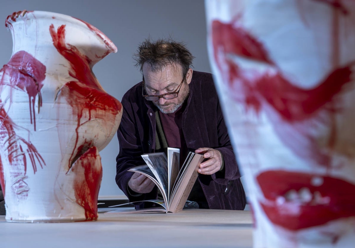 Barceló ojea uno de sus libros entre sus cerámicas en La Pedrera