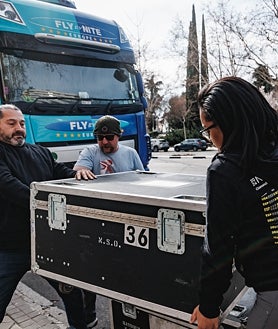 Imagen secundaria 2 - Arriba e izquierda: El equipo técnico de la NSO descarga los instrumentos en la puerta del Palau de la Música Catalana, mientras que en la derecha lo descarga en el Auditorio Nacional de Madrid