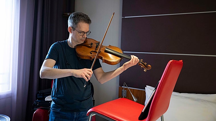 Daniel Foster, primer violista de la NSO, ensaya en su habitación del hotel Le Meridien durante su tiempo libre