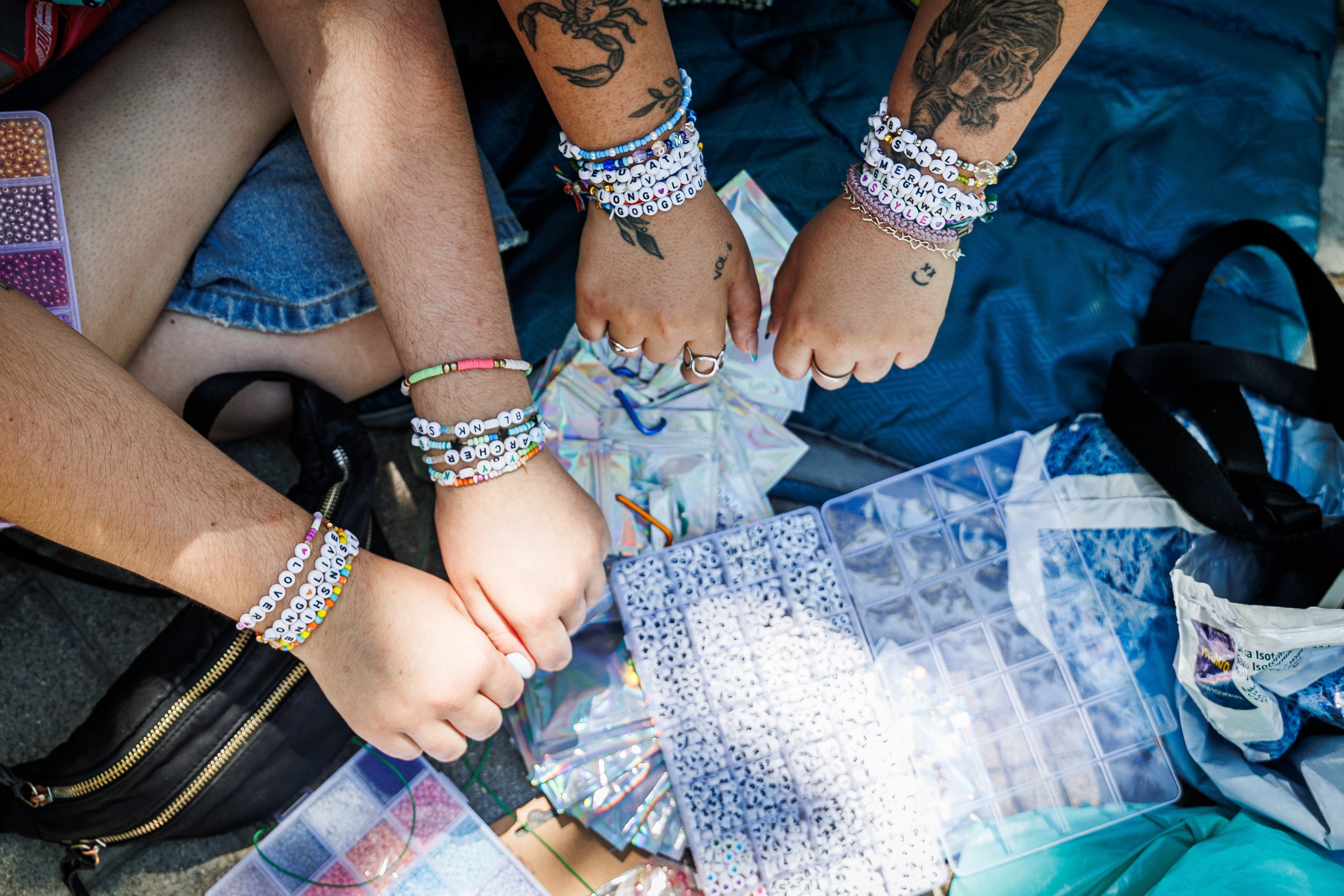 Varias personas muestran sus pulseras ante el Bernabéu