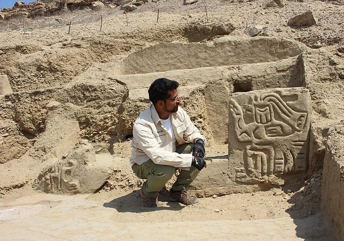 Un investigador junto a un relieve del templo ceremonial descubierto en la región de Lambayeque