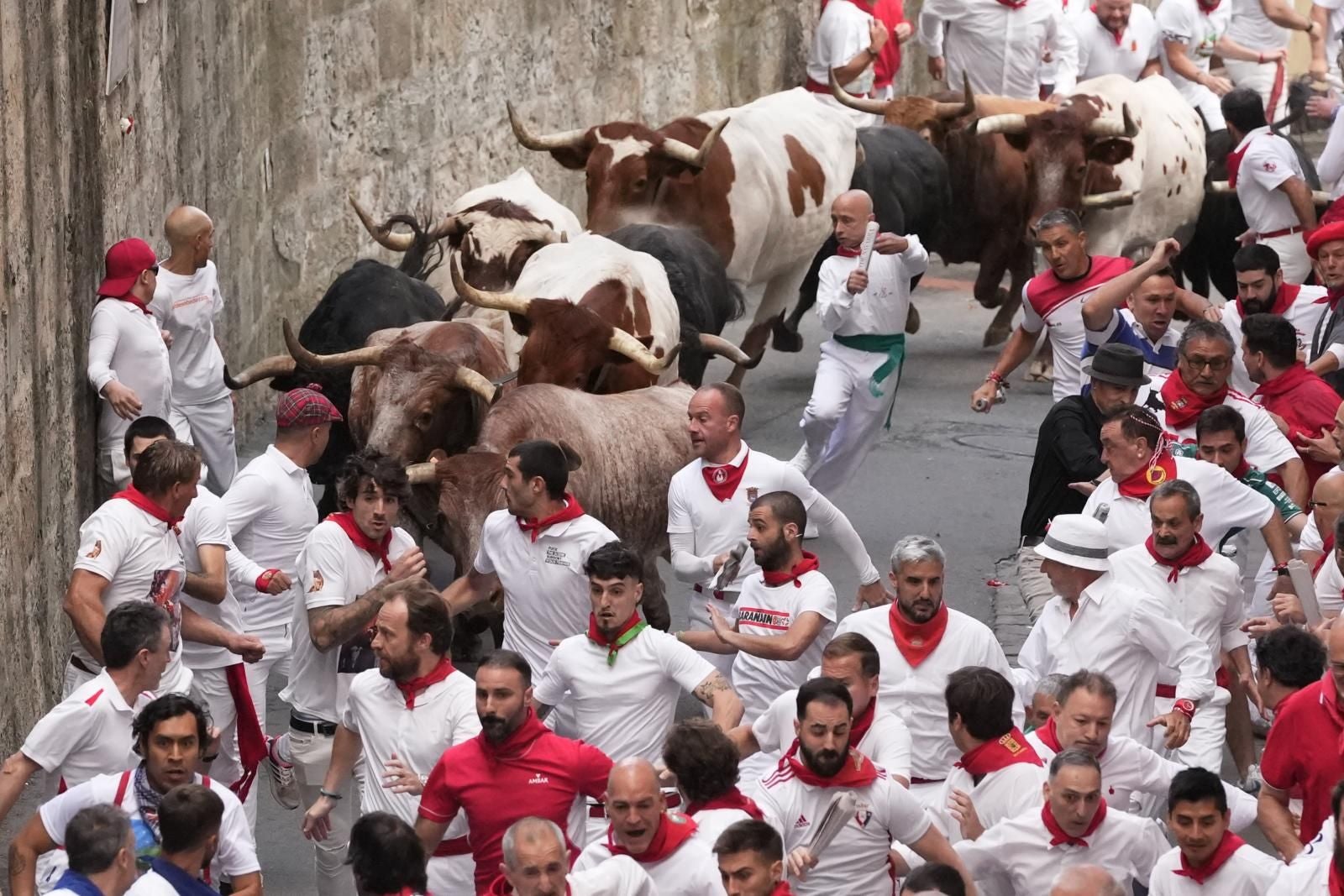 Varios mozos corriendo delante de la manada de Jandilla en el sexto encierro  de San Fermín