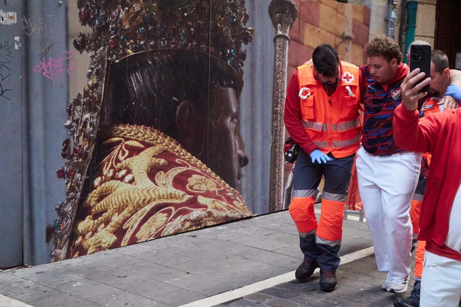 Dos auxiliares de la Cruz Roja trasladan a un herido