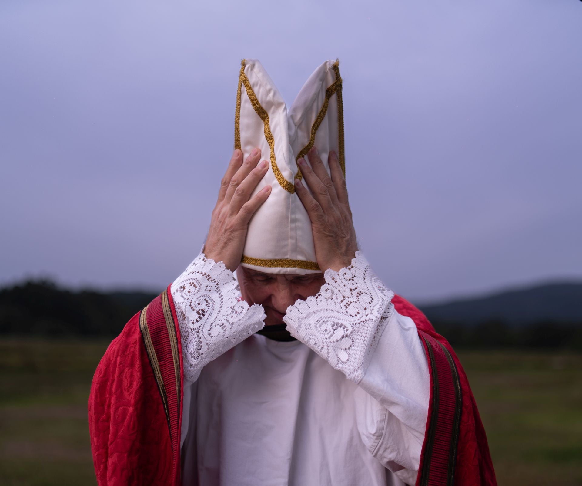 Un participante en uno de los ensayos se ajusta la mitra