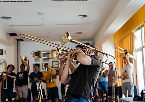 Imagen secundaria 1 - Arriba, Ricardo Mollá dirigiendo durante uno de los conciertos del Numskull Brass Festival. Izquierda, Ricardo Mollá durante una de las clases del curso. Derecha, algunos chicos que participan tocando sus instrumentos.