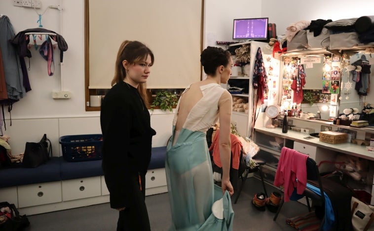 Imagen principal - Arriba: Tras la actuación, la bailarina se desviste y guarda su traje. Izquierda: La bailarina saluda a algunos seguidores que se han acercado hasta la puerta de los artistas para que Itziar les firme algunos autógrafos. Derecha: Itziar se descalza las zapatillas de punta después de todo un día con ellas
