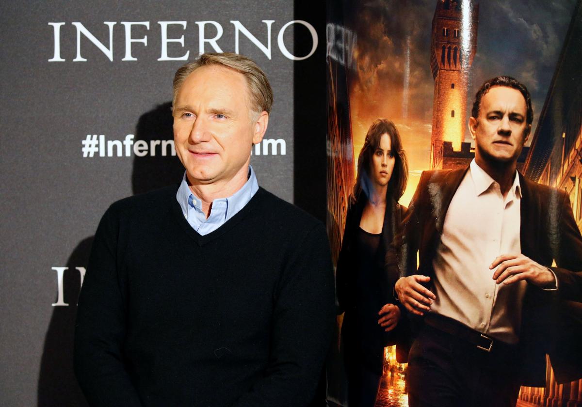 Dan Brown, junto a un cartel de 'Inferno', la tercera película sobre sus novelas llevada al cine