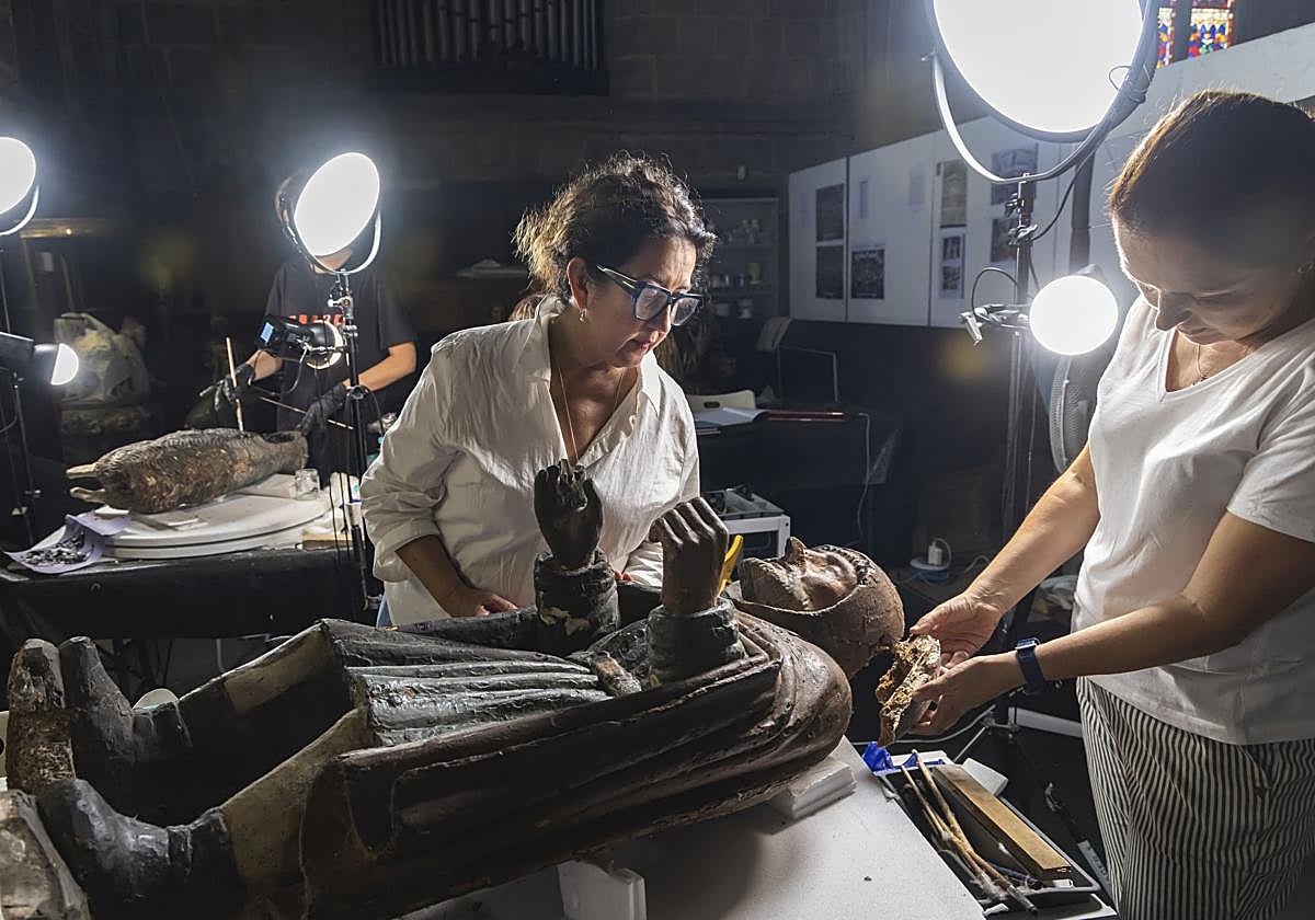 Dos restauradoras con una figura del Belén de la Sang