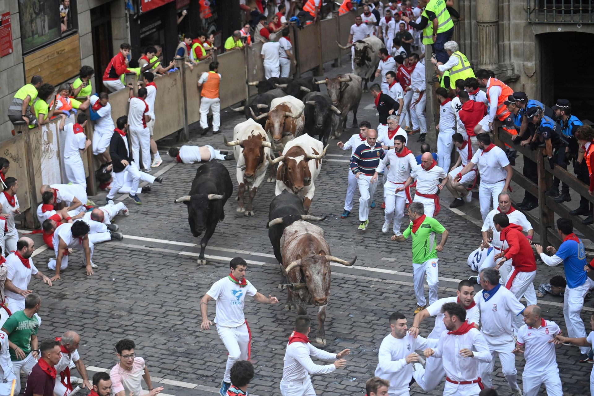 Participantes en el último encierro de los Sanfermines 2025 corren delante de los toros de Miura.