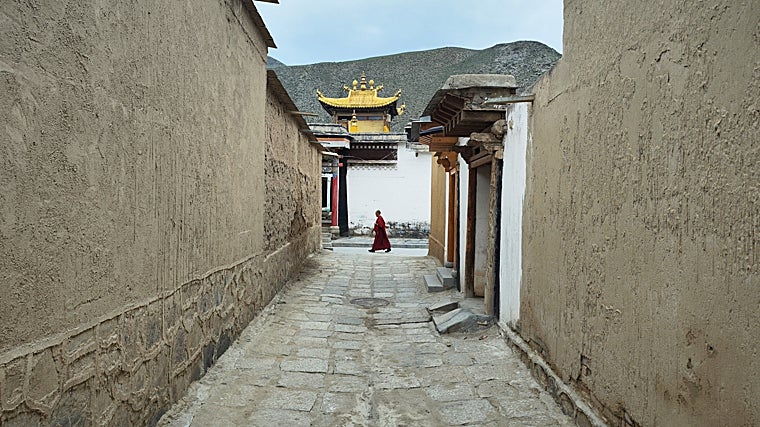 Un monje tibetano avanza entre las calles del monasterio de Labrang