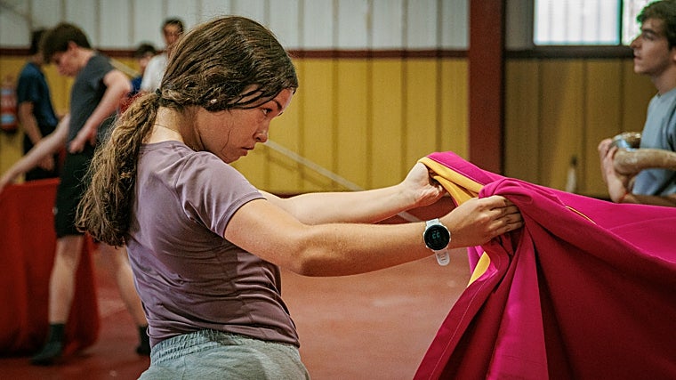 Carla, una de las chicas de la escuela, capote en mano
