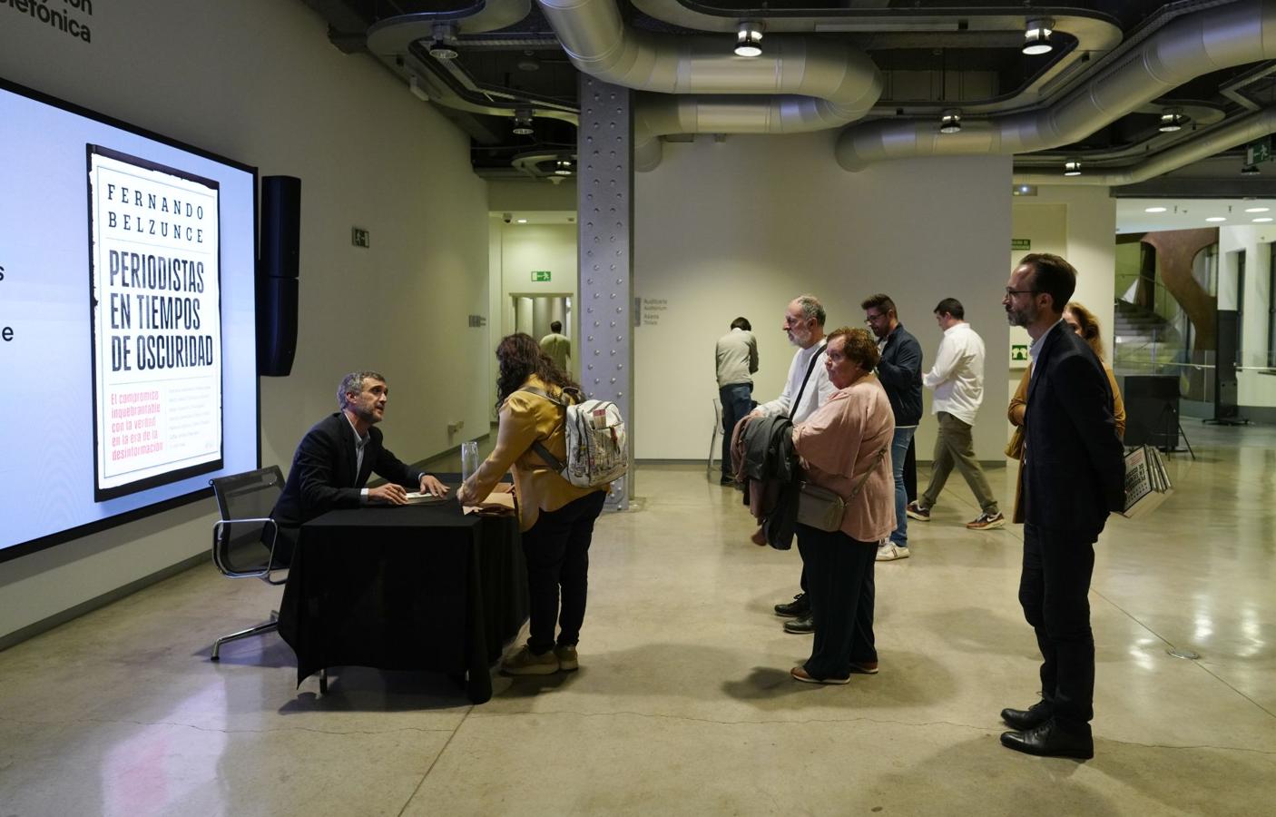 El director general editorial de Vocento firma ejemplares a los asistentes.