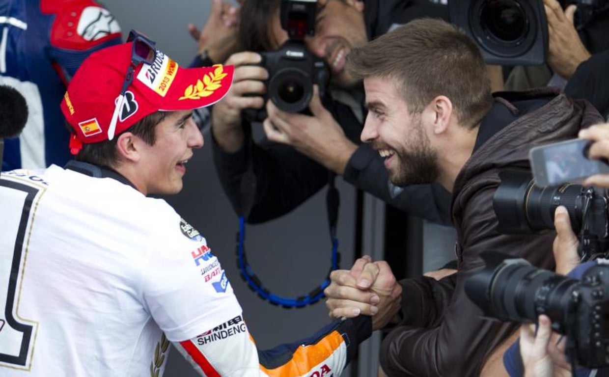 Gerard Piqué saluda a Marc Márquez tras la carrera en Valencia en 2013