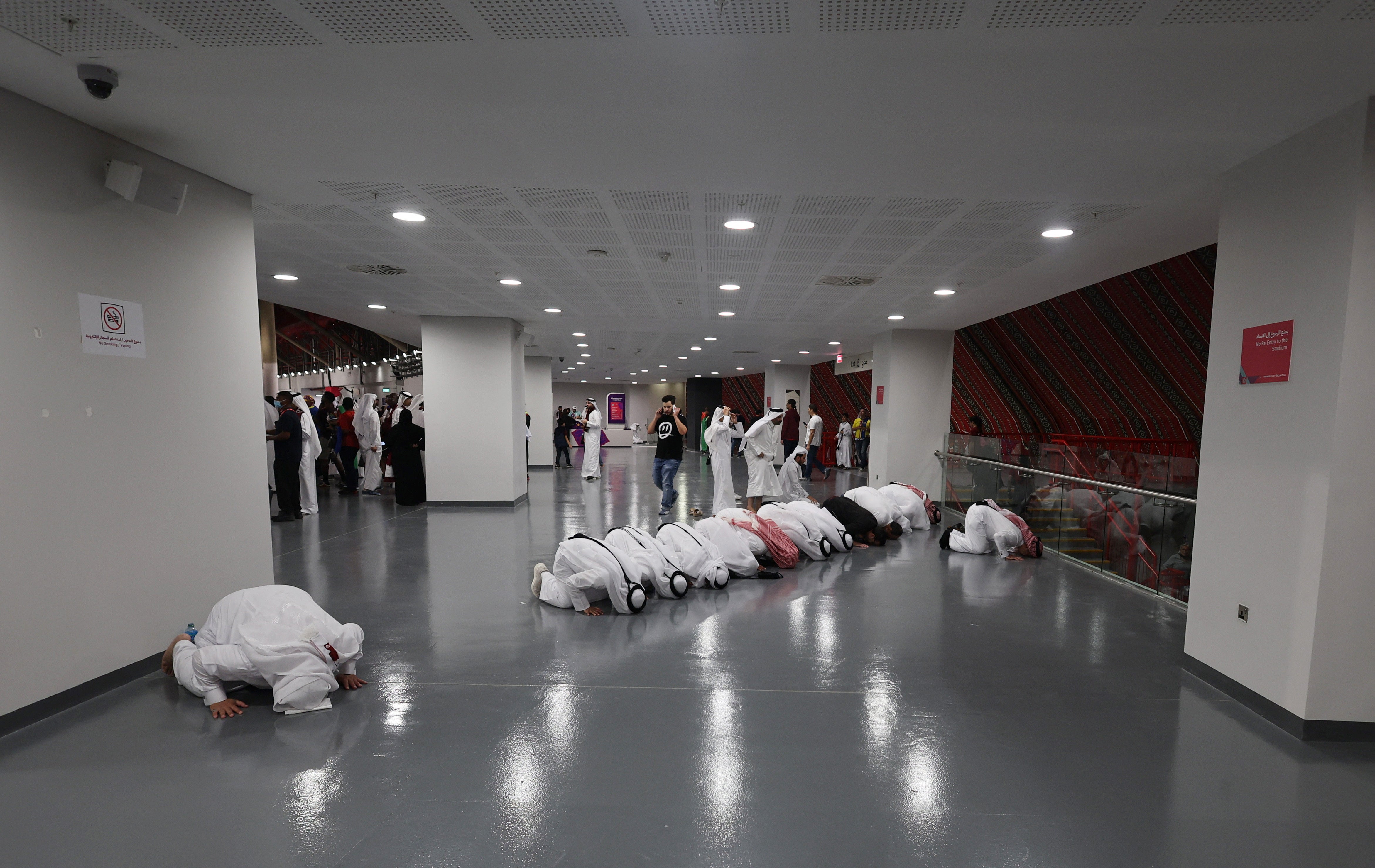 Un grupo de gente rezando dentro del estadio antes de que de comienzo el partido