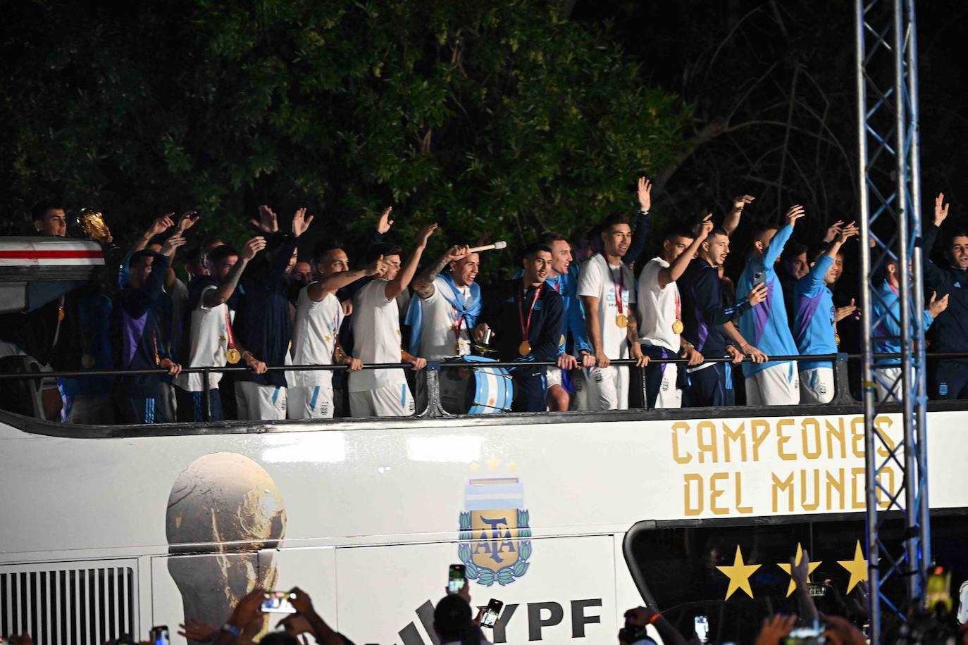 Los jugadores saludando a los miles de aficionados congregados para recibirles