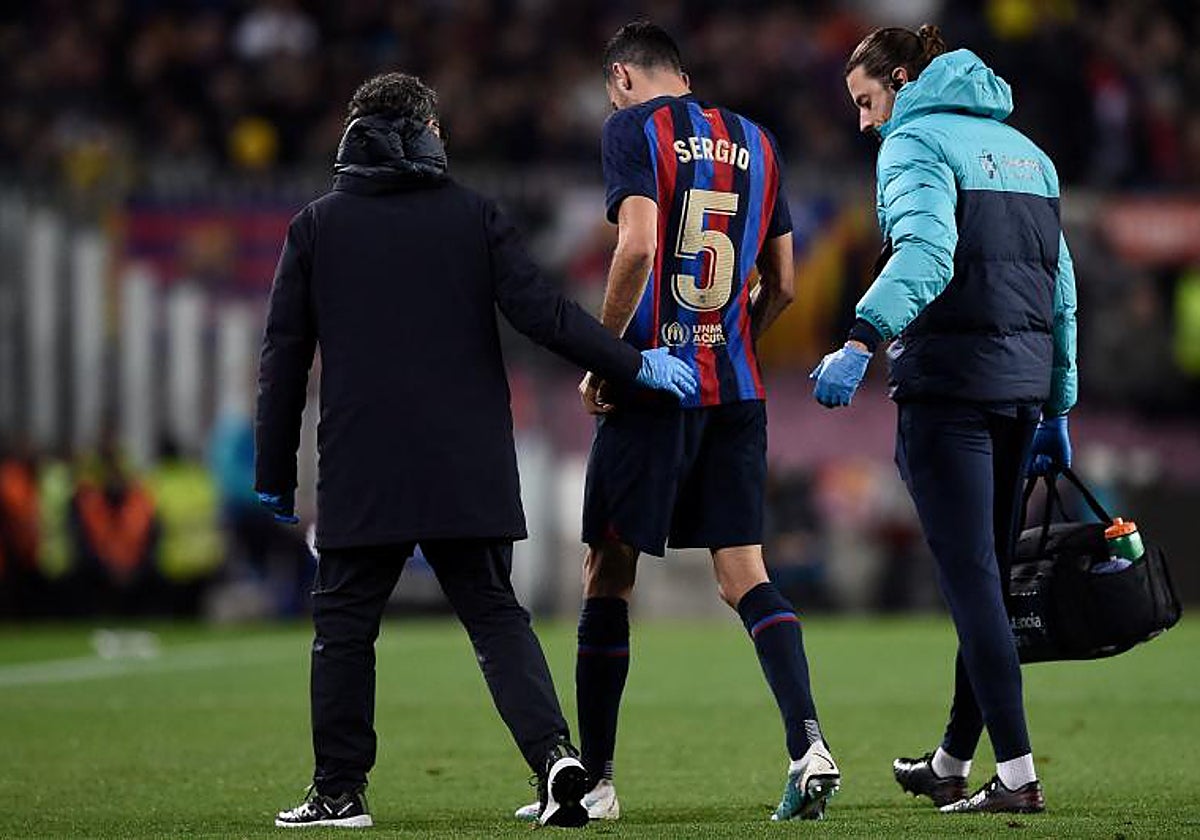 Sergio Busquets se retira del terreno de juego acompañado por los médicos del Barcelona
