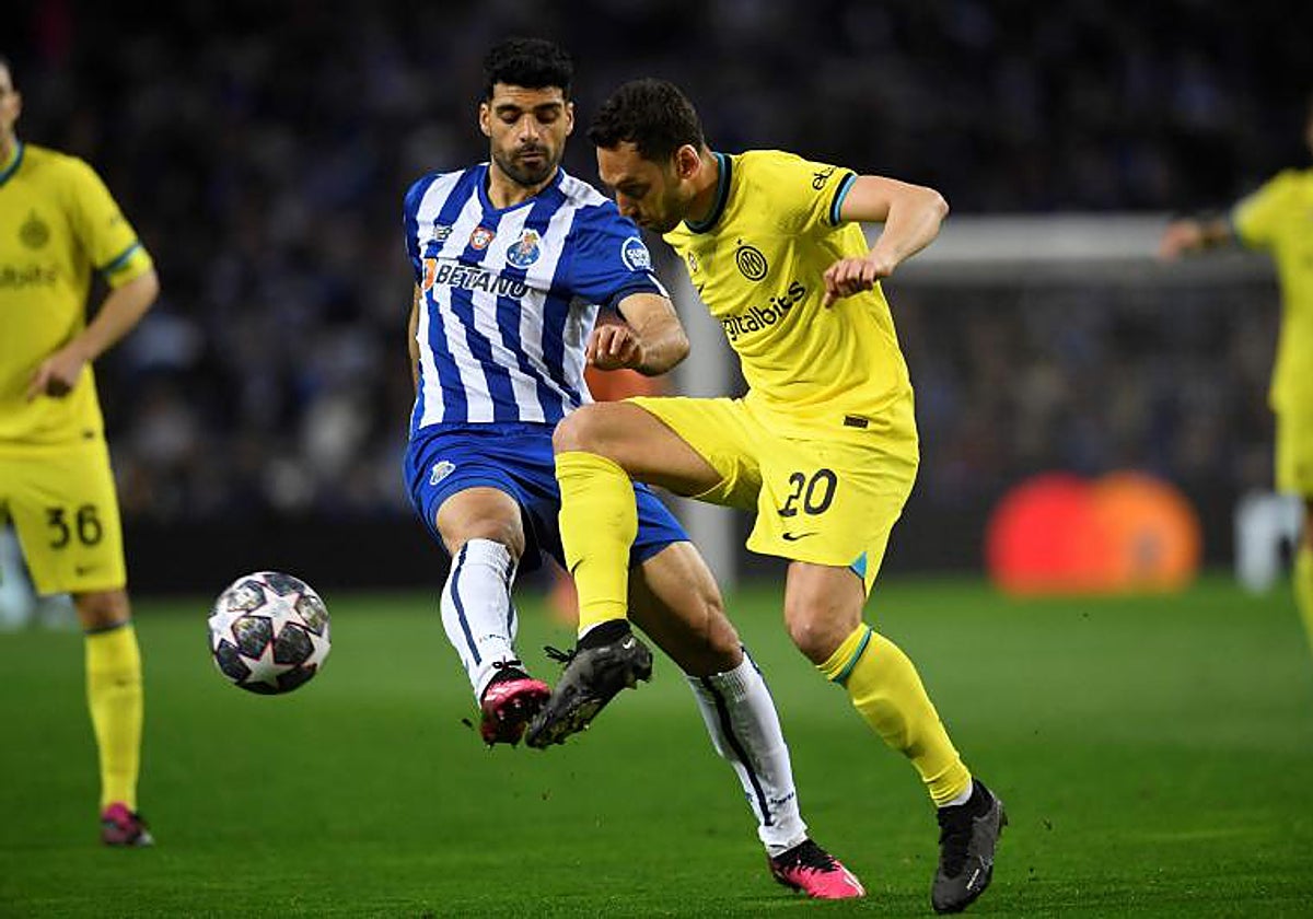 Hakan Calhanoglu pugna con Taremi en el Oporto-Inter