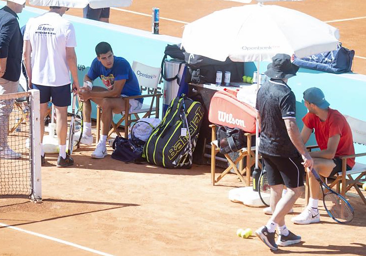 Carlos Alcaraz charla con Grigor Dimitrov durante un entrenamiento en la Caja Mágica