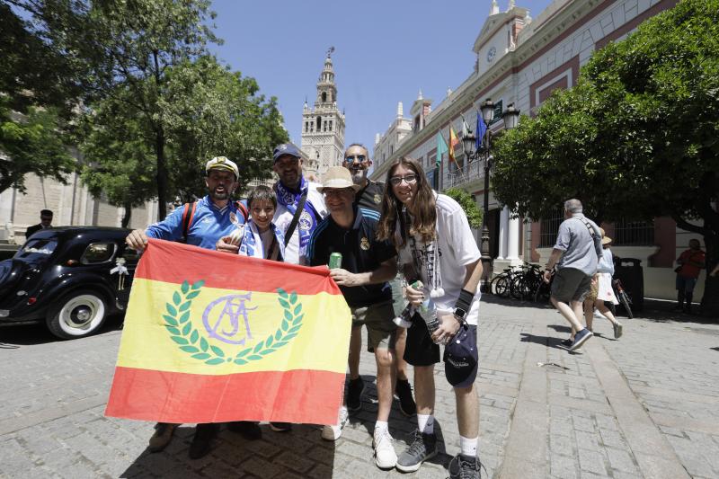 Aficionados del Real Madrid posan orgullosos con su bandera por las calles de Sevilla