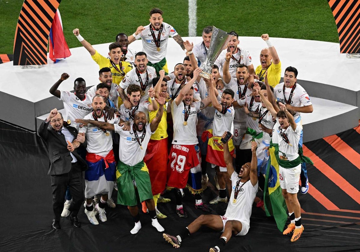 Rakitic y Navas, rodeados de todo el equipo, alzan el trofeo en el Psukas Arena de Budapest