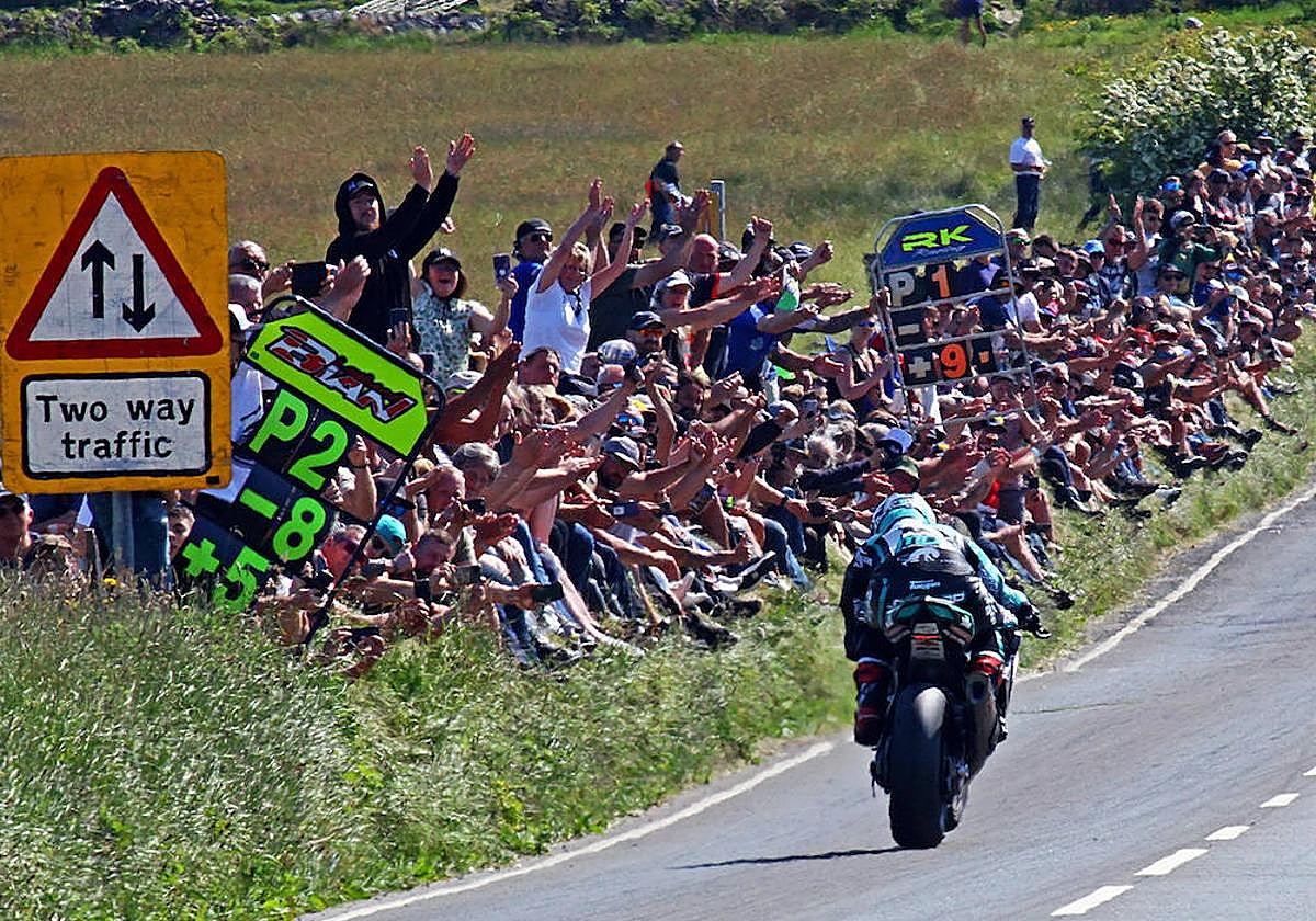 Aficionados jalean desde el arcén a un competidor en el TT de la Isla de Man