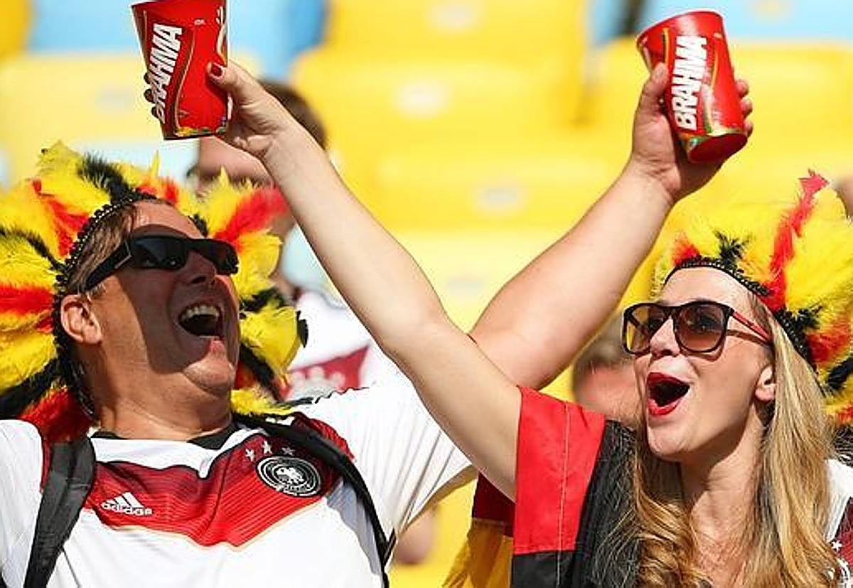 Imagen de archivo de dos aficionados con vasos de cerveza en un estadio