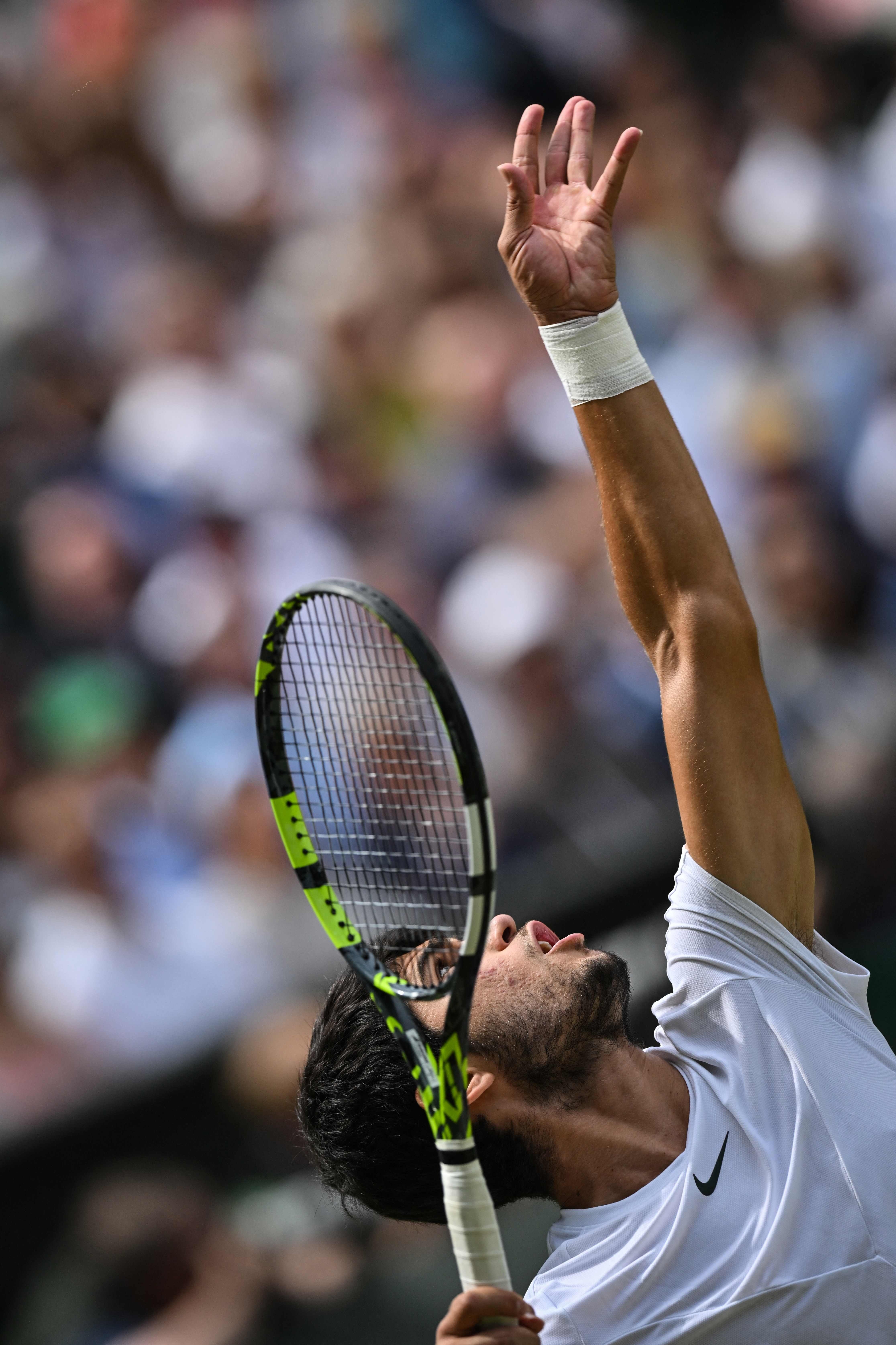 El español Carlos Alcaraz sirve contra el serbio Novak Djokovic durante su último partido de tenis individual masculino el último día del Campeonato de Wimbledon 2023