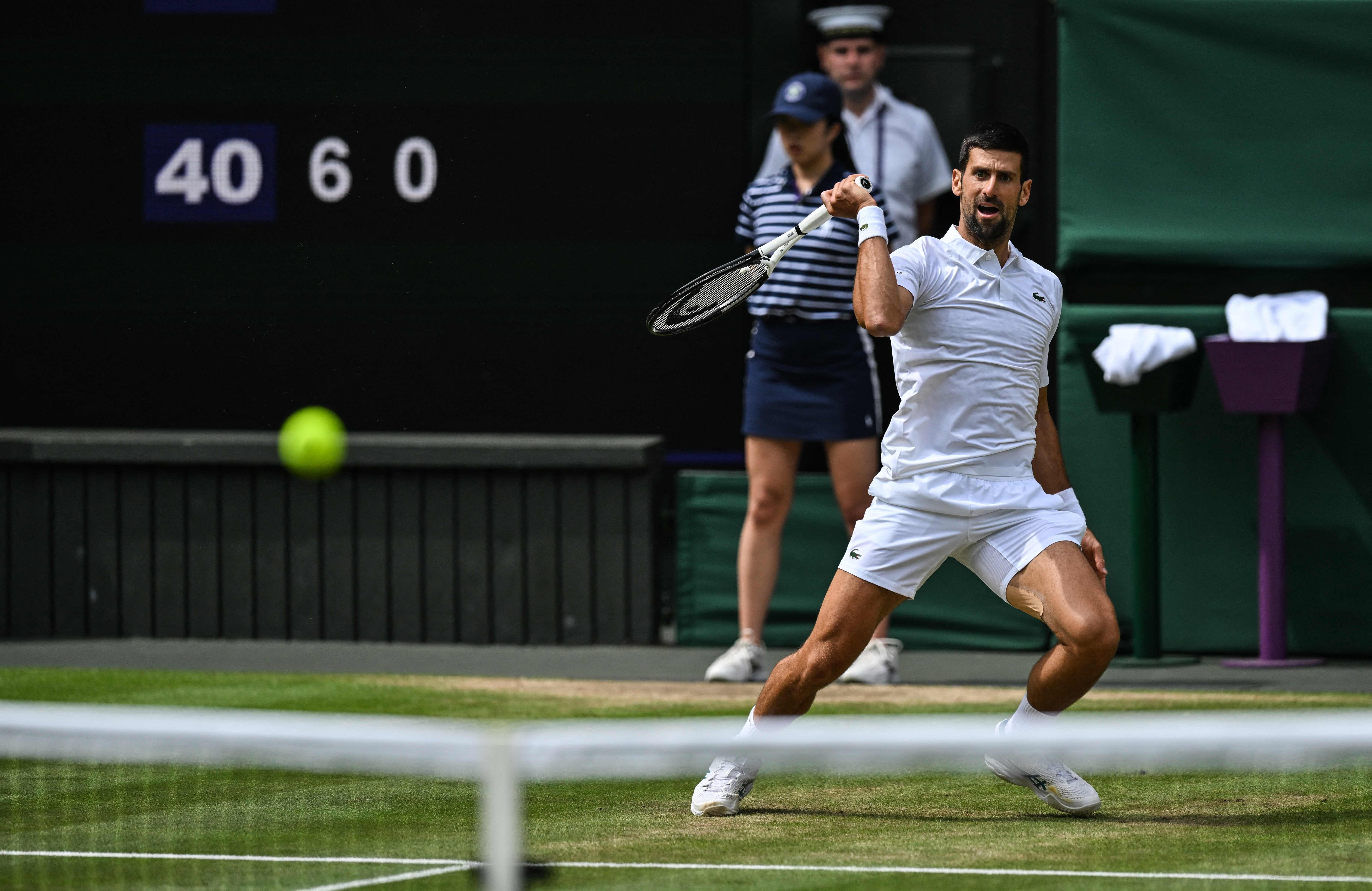 El serbio Novak Djokovic le devuelve el balón al español Carlos Alcaraz durante el último partido de tenis individual masculino en el último día del Campeonato de Wimbledon 2023