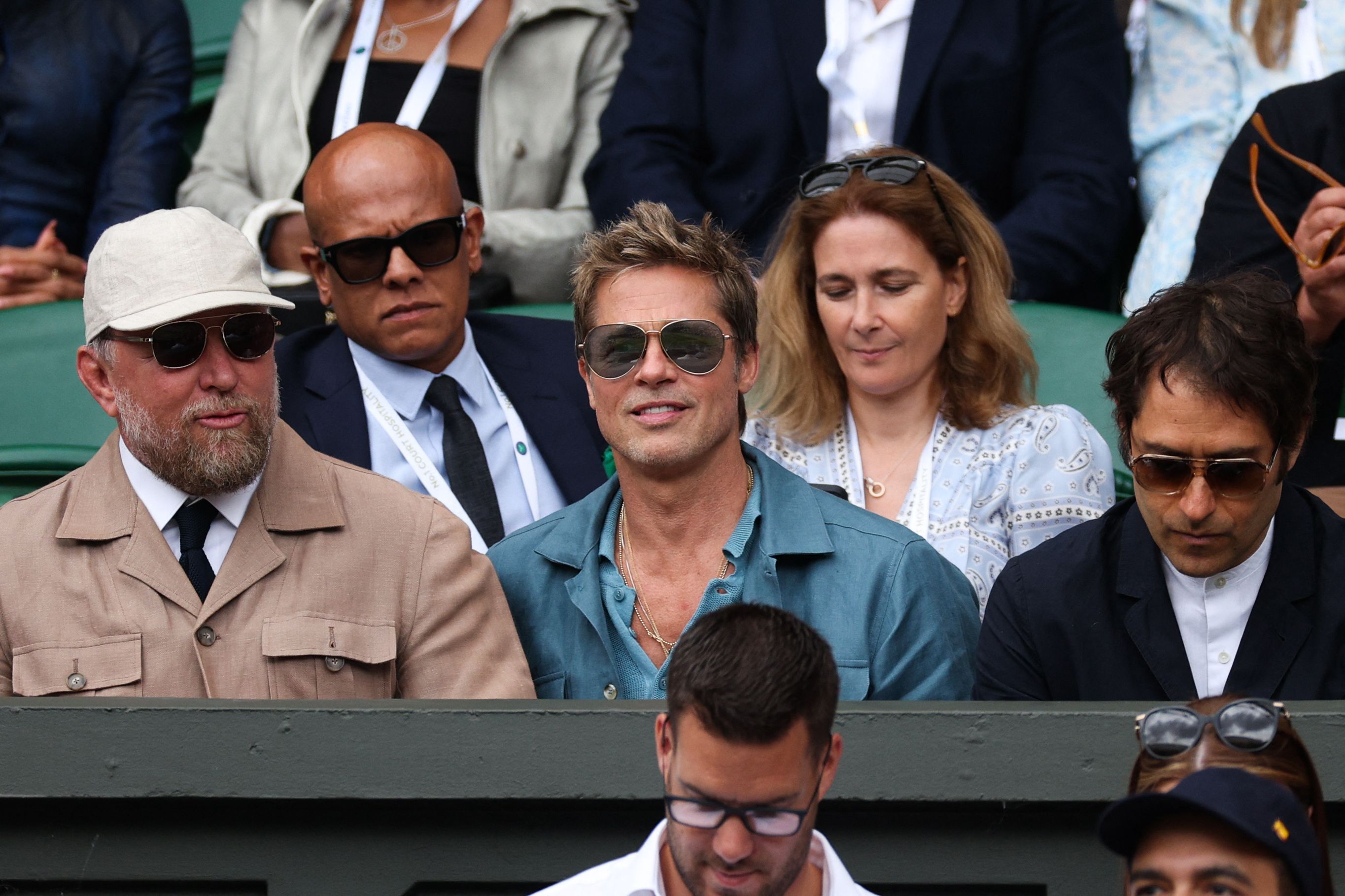 El actor Brad Pitt (centro) aparece en el palco real de la cancha central para ver la final de Wimbledon