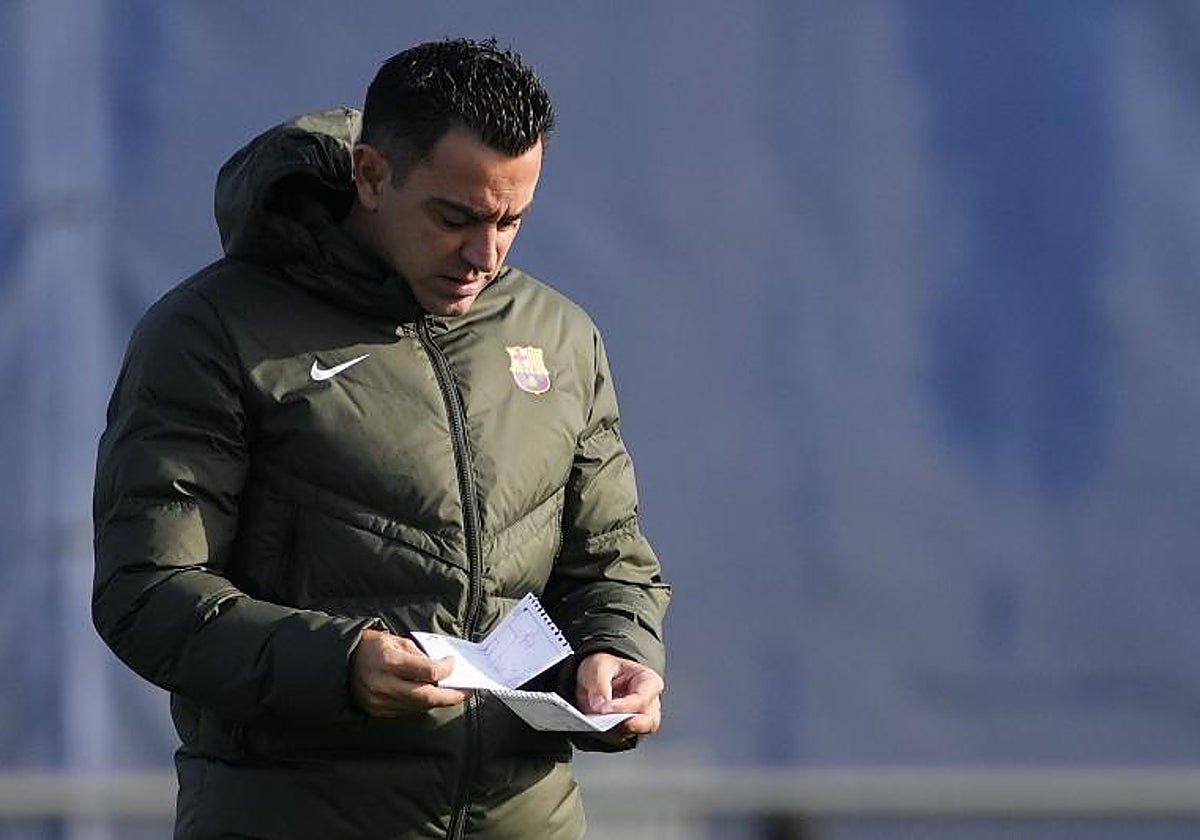 Xavi consulta unas notas durante el entrenamiento de este sábado