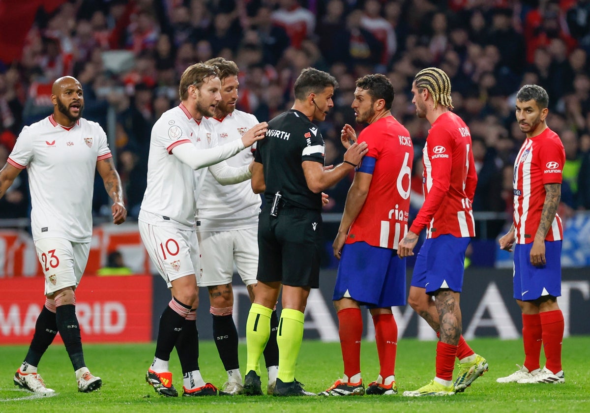 Los jugadores del Sevilla protestan a Gil Manzano junto al capitán atlético Koke
