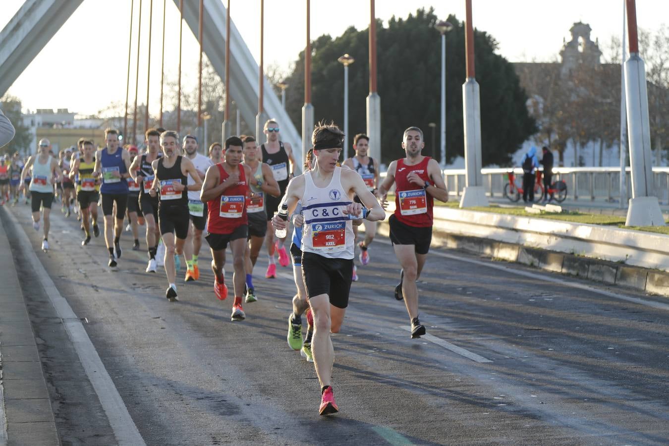 Corredores del maratón a su paso por el puente de la Barqueta