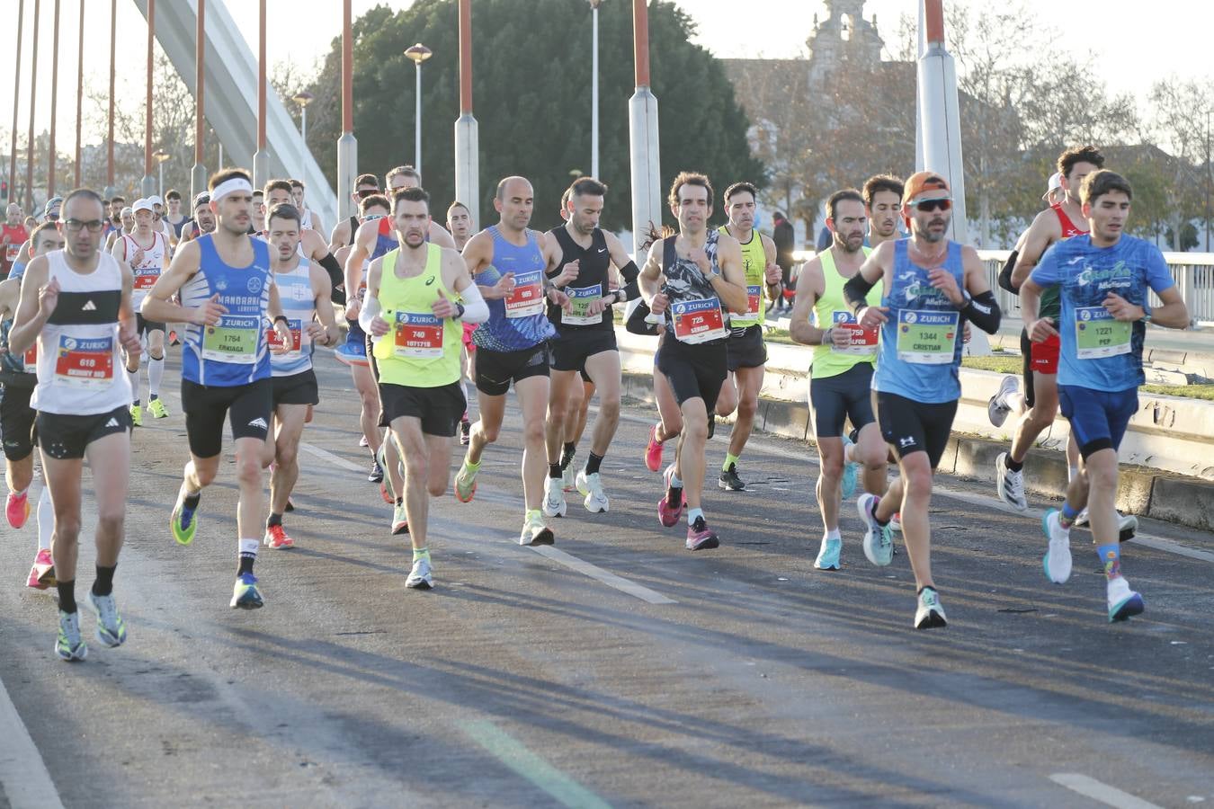 Corredores del maratón a su paso por el puente de la Barqueta