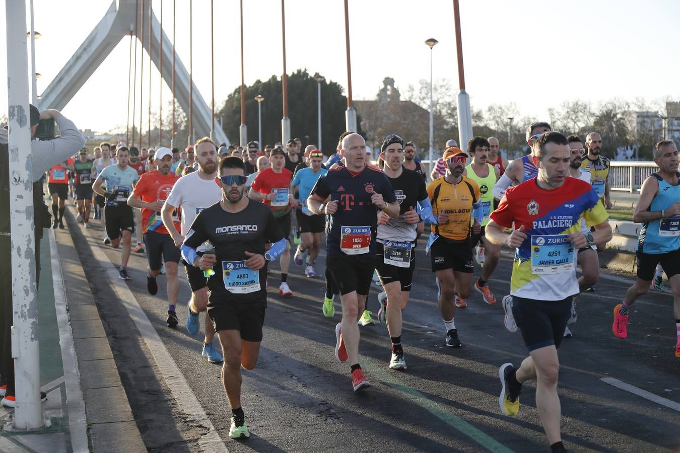 Corredores del maratón a su paso por el puente de la Barqueta