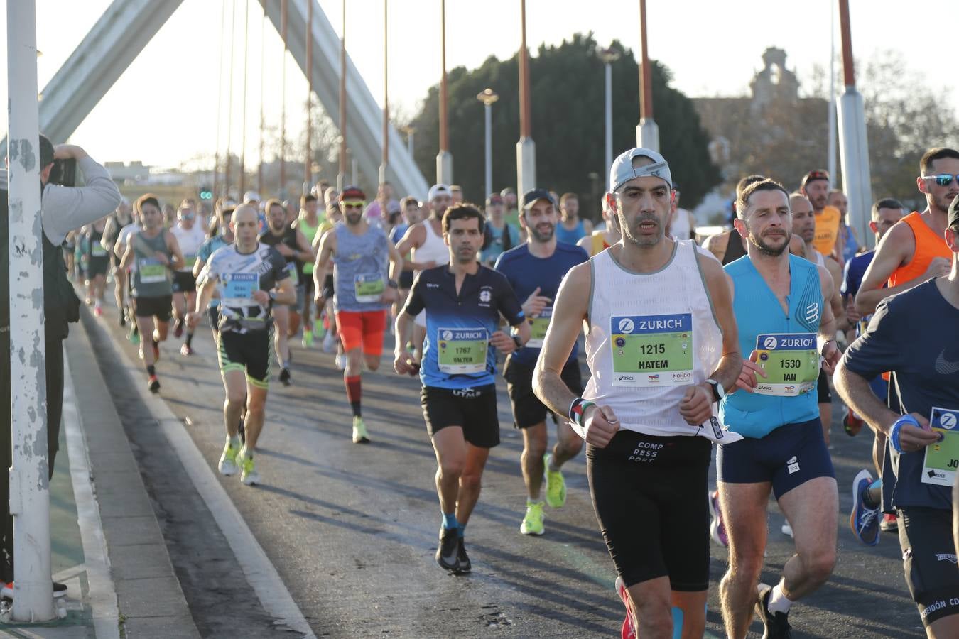 Corredores del maratón a su paso por el puente de la Barqueta