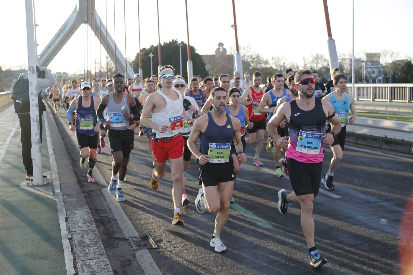 Corredores del maratón a su paso por el puente de la Barqueta