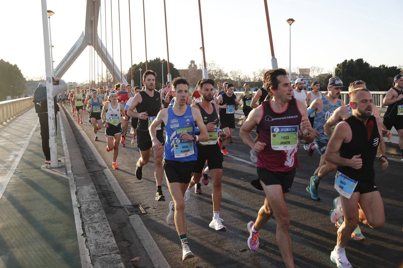 Corredores del maratón a su paso por el puente de la Barqueta