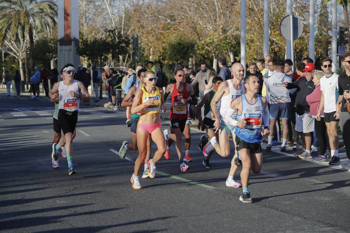 Corredores del maratón a su paso por el puente de la Barqueta