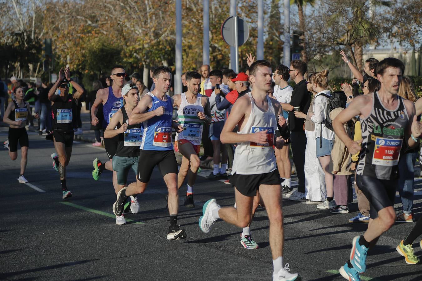 Corredores del maratón a su paso por el puente de la Barqueta
