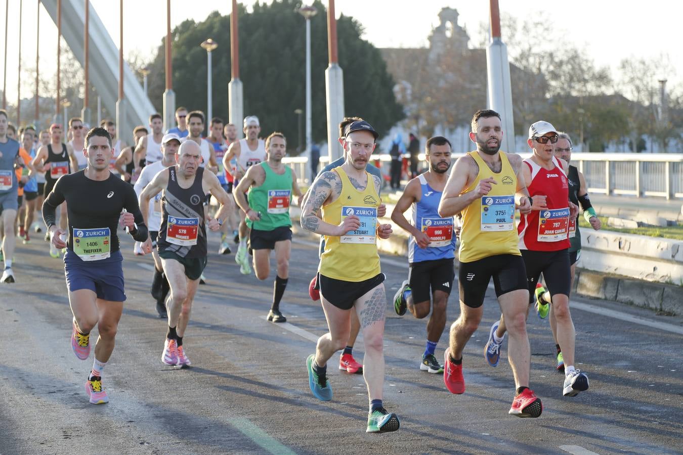 Corredores del maratón a su paso por el puente de la Barqueta
