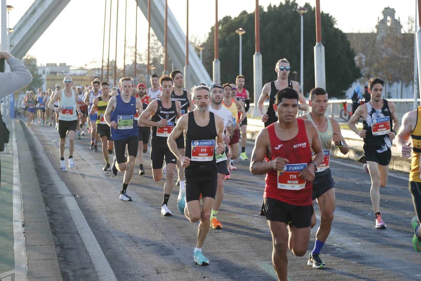 Corredores del maratón a su paso por el puente de la Barqueta