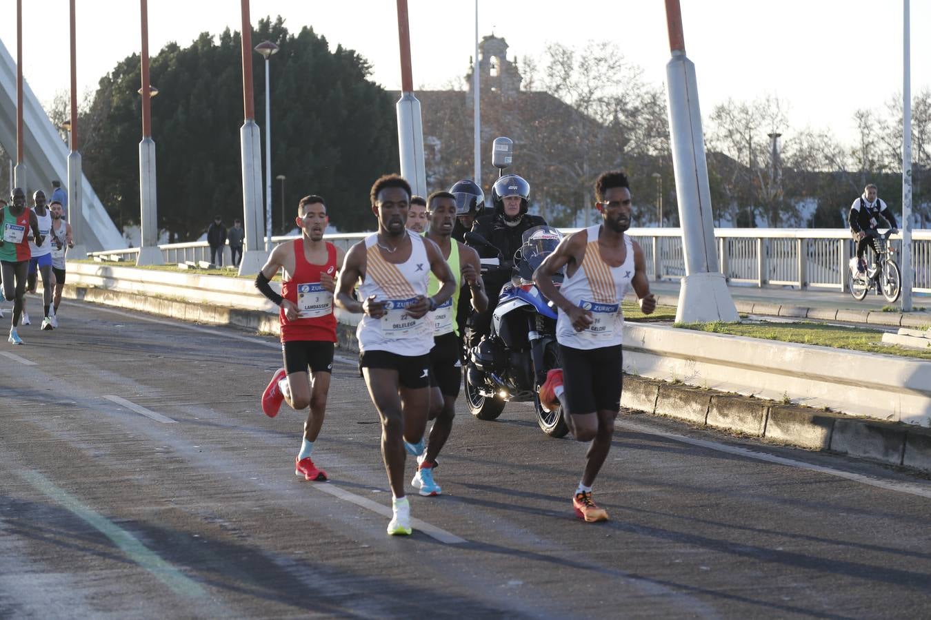 Corredores del maratón a su paso por el puente de la Barqueta