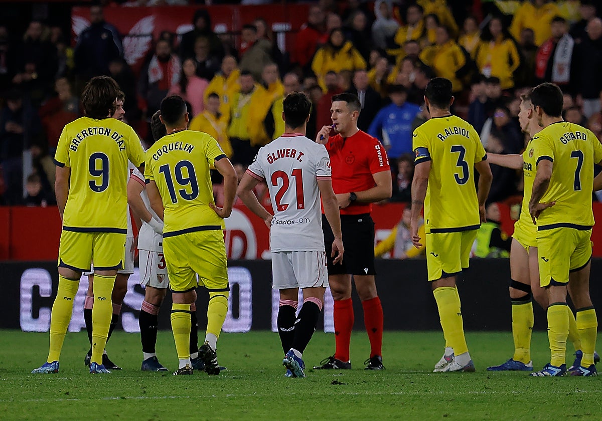 Los jugadores de Villarreal y Sevilla rodean a Díaz de Mera Escuderos