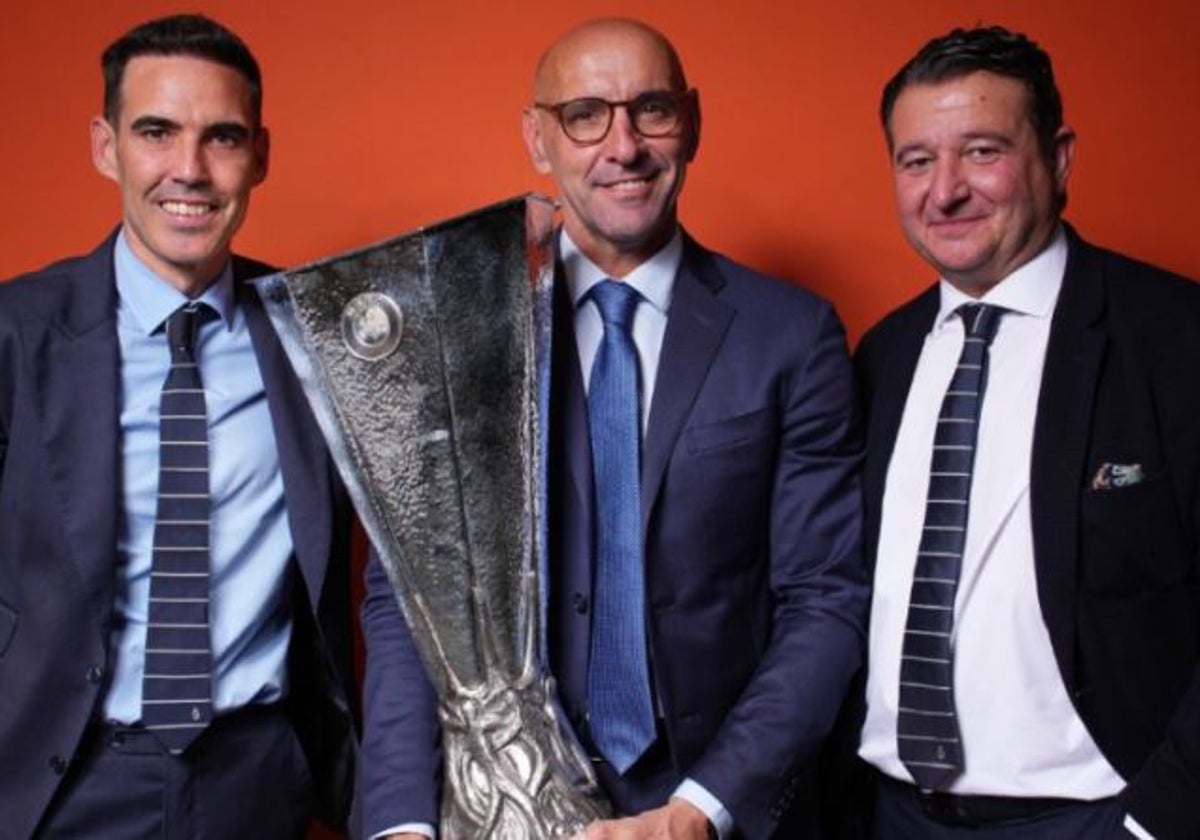 Monchi levanta en el centro la séptima y última Europa League lograda por el Sevilla, la de Budapest, flanqueado por Fernando Navarro y Emilio de Dios
